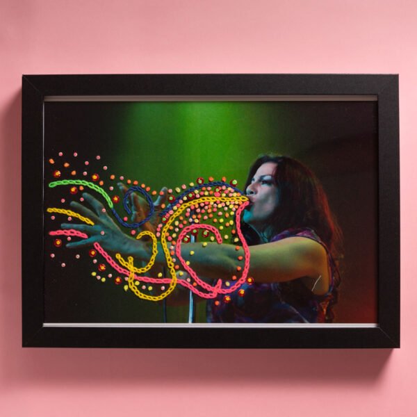 La cantante MimiMaura en vivo durante un show en Buenos Aires en el 2008. 
Toma e impresión digitales. 
Bordado a mano con hilos y lentejuelas en Valencia, España, 2026.

Medidas con marco: 20x30cm 

Pieza única / DISPONIBLE
